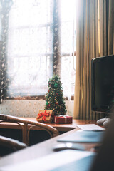 Christmas tree and wapped present boxing decorated at home office with laptop computer.