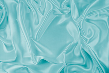 Obraz premium Photography of beautiful wavy turquoise silk satin luxury cloth fabric, abstract background design.