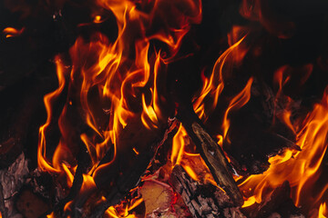 Wooden sticks and boards are burned in the fire. Fire, coal, smoke. The fiery background.