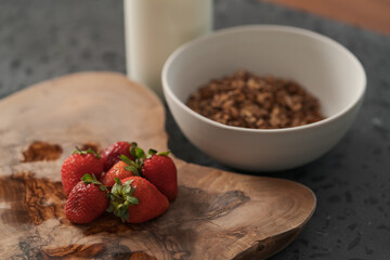 Organic oat granola with strawberry and yogurt on concrete background