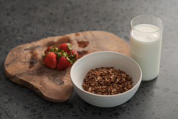 Organic oat granola with strawberry and yogurt on concrete background