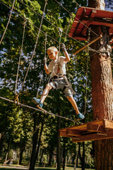 Little boy in rope park, climber on playground