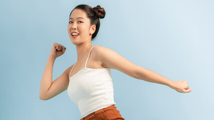 happy young excited shocked woman posing isolated over blue wall background looking aside.