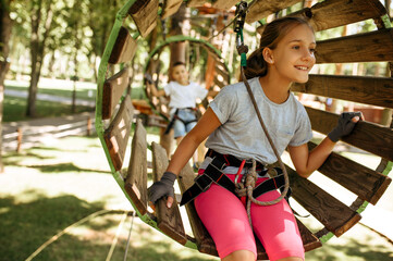 Obraz na płótnie Canvas Smiling kids climbs in rope park, playground