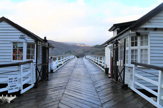 The old, grade 2 listed Toll Bridge and Toll House crossing the Mawddach river at Penmaenpool, Gwynedd, Wales, UK.