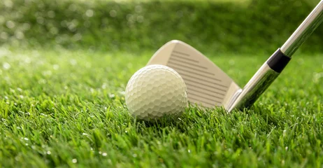 Rolgordijnen Golf stick and ball on green grass golf course, close up view. © Rawf8