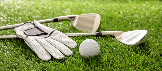 Golf equipment on green grass golf course, close up view.