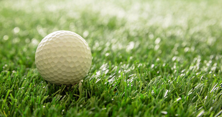 Golfball on green grass golf course, close up view.