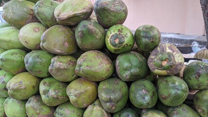 Close up view of green coconuts in india's market. Pile of fresh coconuts cut in the shape for drinking coconut water