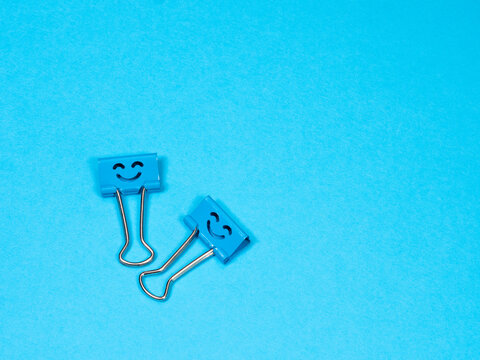 Funny Smile Blue Metal Binder Clip Or Paperclip On Blue Background With Copyspace For Text