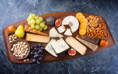 Modern Style traditionelle Party Platte mit Käse, Obst und Snacks als Draufsicht auf einen Design Holz Board 