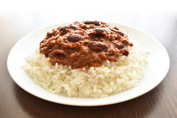 Chilli con carne with rice on a white plate.