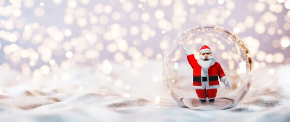 Santa Claus in glass ball on snow