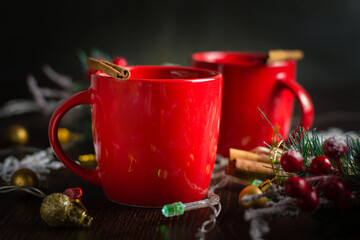 Delicious mulled wine alcoholic warm drink with cinnamon in red cups. Christmas anticipation concept.
