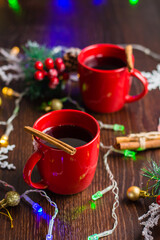 Obraz na płótnie Canvas Delicious mulled wine with cinnamon in red cups. Concept waiting for christmas, top view, vertical format