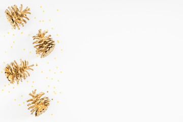 Christmas holiday composition. Golden cones. Xmas golden decorations on white background. Christmas, New Year, winter concept. Flat lay, top view, copy space