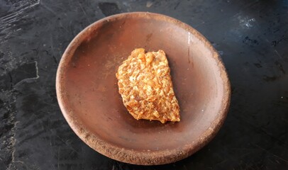 brown tempe or fried tempe on bowl or tempe goreng disajikan di wadah dari tanah liat