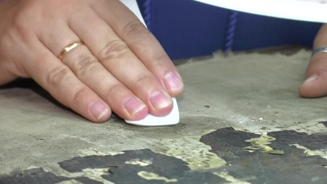 Closeup of Restorer working on the old icon at workshop. Restoration and conservation of a very old canvas, restoration of a painting, restorer at work

