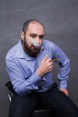 Armenian man with beard and braces smokes on gray background