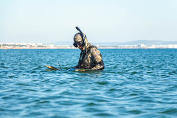 Diver with diving equipment at sea. The man is fishing in the sea. Spearfishing.