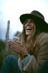 Girl in the woods wearing denim overalls and a cowboy fedora hat. Autumn vives.