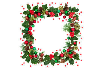 Fototapeta na wymiar Christmas abstract square wreath decoration with holly, loose berries, red & green bauble decorations & winter greenery on white background. Decorative border for the festive season.