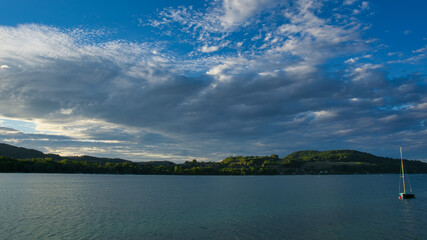 Sunset on a lake with clouds and boat