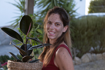 Close portrait of caucasian woman with a flowerpot in her hands