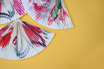 hand fans on a yellow background