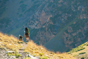 Group of young hikers trekking in mountains. Two women two men backpacking in summer near Sary...