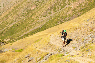 Obraz premium Male Hiker. Young man alone trekking and backpacking near Sary Chelek lake, Sary-Chelek Jalal Abad region, Kyrgyzstan, Trekking in Central Asia.