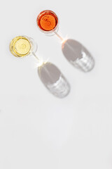 Two glasses of wine with beautiful shadows. Rose and white wine with copy space.