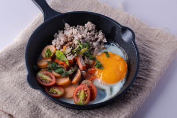 Pan-fried eggs in a black pan on a gray background.