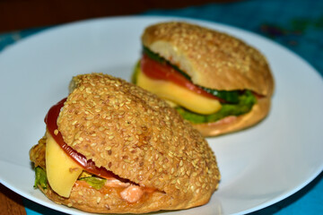 Sandwiches with chicken meat tomatoes and herbs and a sesame bun
