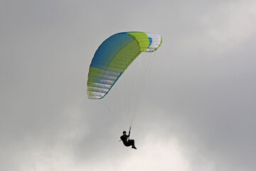Paraglider flying wing in a cloudy sky