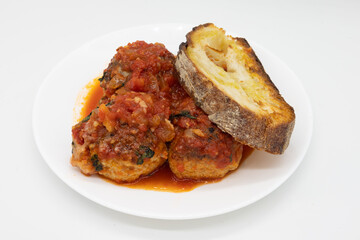 Italian Style Meatballs with Garlic Bread on a White Plate