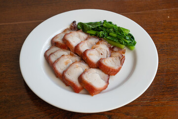 roast barbecue red pork or Cantonese barbecued pork with vegetable - chinese style on white plate.