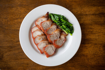 roast barbecue red pork or Cantonese barbecued pork with vegetable - chinese style on white plate.