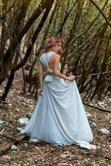 A woman in a white dress in the woods