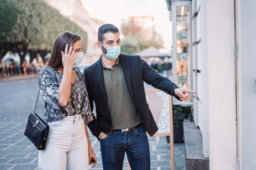 Newlywed couple walks through the streets of the center looking at the shops, they wear protective masks against the spread from the coronavirus pandemic.