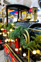 Festive steam train at the Christmas market. Christmas decor. Exhibition of sweets for children. New Year's fair and Christmas decorations.