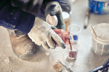Fototapeta na wymiar Worker mixing paint during home renovation.