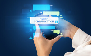 Female hand typing on smartphone with ONLINE COMMUNICATION inscription, social networking concept