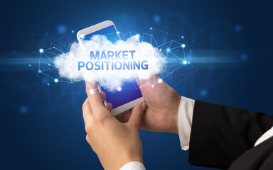 Female hand touching smartphone with MARKET POSITIONING inscription, cloud business concept