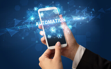 Female hand holding smartphone with AUTOMATION inscription, modern technology concept