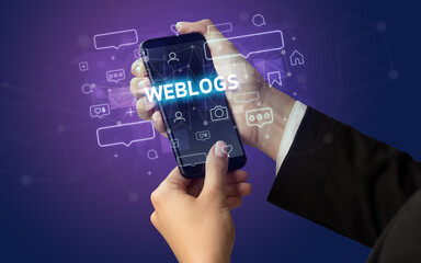 Female hand typing on smartphone with WEBLOGS inscription, social media concept