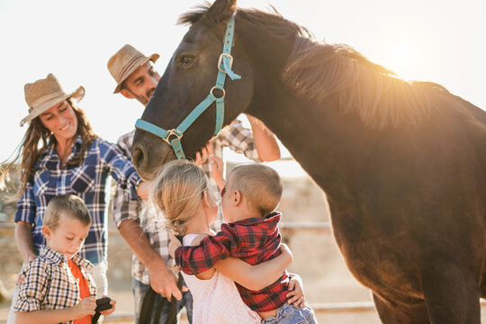 Happy family enjoy day with horse on ranch - Parents, children and animal love