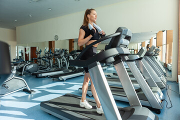 Fototapeta na wymiar Beautiful sexy athletic woman running on a treadmill at the gym