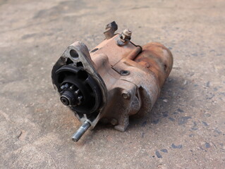 Old automotive starter motor  place on the concrete floor 