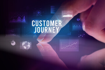 Finger touching tablet with charts and CUSTOMER JOURNEY inscription, business concept